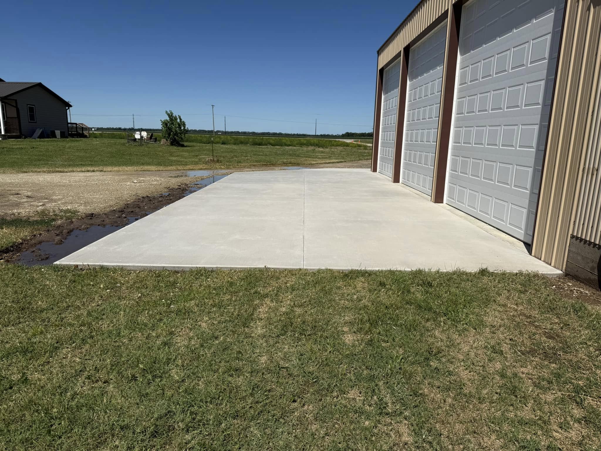 Fresh concrete pad in front of garage bays